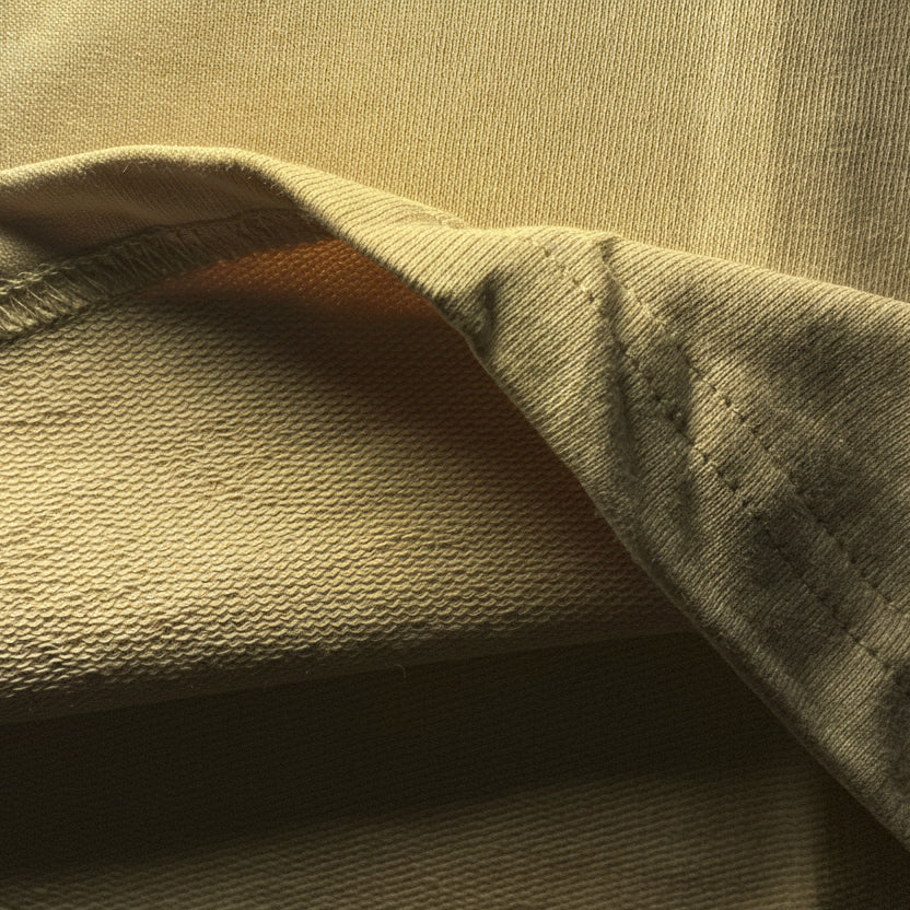 Close-up of beige fabric with visible French terry texture.