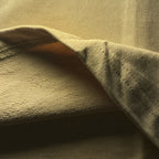 Close-up of beige fabric with visible French terry texture.