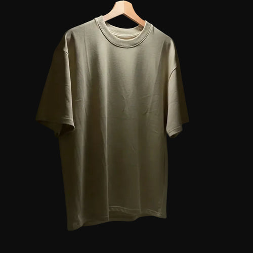 Beige t-shirt on a hanger against a black background