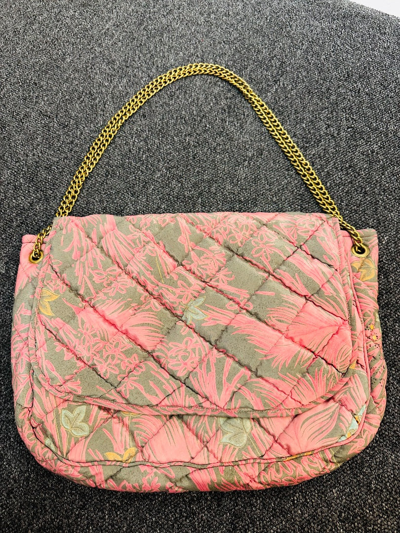 Gray t-shirt on a hanger against a dark background with a light source above.