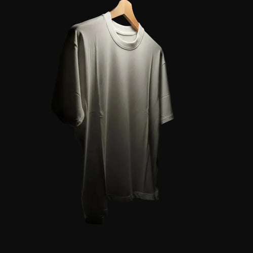Gray t-shirt on a hanger against a dark background with a light source above.