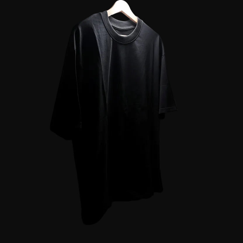 Black t-shirt on a hanger against a black background