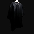 Black t-shirt on a hanger against a black background